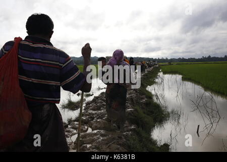 Teknaf, Bangladesh. 09e septembre 2017. Un garçon de Rohingya réagit à la caméra en se promenant sur un sentier boueux après avoir traversé la frontière entre le Bangladesh et le Myanmar, à Teknaf. Le réfugié Rohingya marche sur un sentier boueux après avoir traversé la frontière entre le Bangladesh et le Myanmar, à Teknaf. Crédit: Md Mehedi Hasan/Pacific Press/Alay Live News Banque D'Images