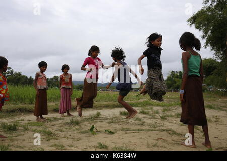 Teknaf, Bangladesh. 10 septembre 2017. Les enfants réfugiés Rohingya jouent sur la zone de terre de No man près de la frontière entre le Bangladesh et le Myanmar, à Naikhongchhari, Bandarban. Le réfugié Rohingya marche sur un sentier boueux après avoir traversé la frontière entre le Bangladesh et le Myanmar, à Teknaf. Crédit: Md Mehedi Hasan/Pacific Press/Alay Live News Banque D'Images