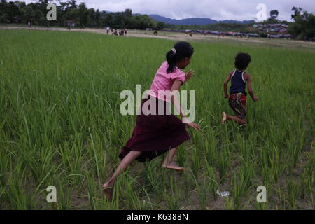 Teknaf, Bangladesh. 10 septembre 2017. Les enfants réfugiés Rohingya jouent sur la zone de terre de No man près de la frontière entre le Bangladesh et le Myanmar, à Naikhongchhari, Bandarban. Le réfugié Rohingya marche sur un sentier boueux après avoir traversé la frontière entre le Bangladesh et le Myanmar, à Teknaf. Crédit: Md Mehedi Hasan/Pacific Press/Alay Live News Banque D'Images