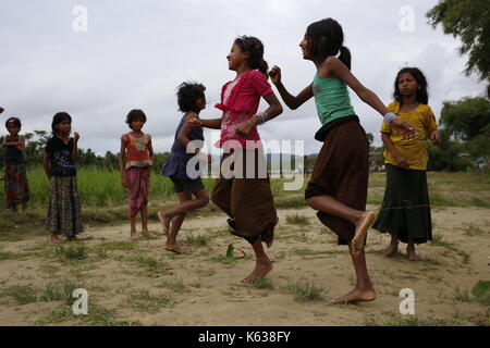 Teknaf, Bangladesh. 10 septembre 2017. Les enfants réfugiés Rohingya jouent sur la zone de terre de No man près de la frontière entre le Bangladesh et le Myanmar, à Naikhongchhari, Bandarban. Le réfugié Rohingya marche sur un sentier boueux après avoir traversé la frontière entre le Bangladesh et le Myanmar, à Teknaf. Crédit: Md Mehedi Hasan/Pacific Press/Alay Live News Banque D'Images