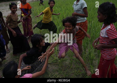 Teknaf, Bangladesh. 10 septembre 2017. Les enfants réfugiés Rohingya jouent sur la zone de terre de No man près de la frontière entre le Bangladesh et le Myanmar, à Naikhongchhari, Bandarban. Le réfugié Rohingya marche sur un sentier boueux après avoir traversé la frontière entre le Bangladesh et le Myanmar, à Teknaf. Crédit: Md Mehedi Hasan/Pacific Press/Alay Live News Banque D'Images