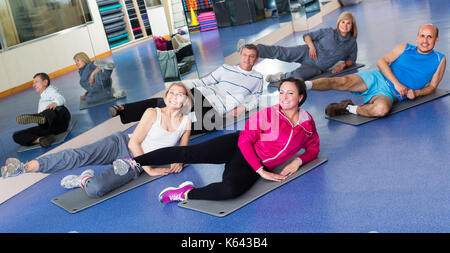 Groupe d'adultes actifs positifs faire pilates dans une routine sport club Banque D'Images