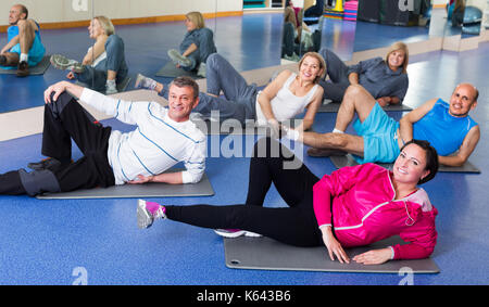 Groupe d'adultes actifs heureux faire pilates dans une routine sport club Banque D'Images