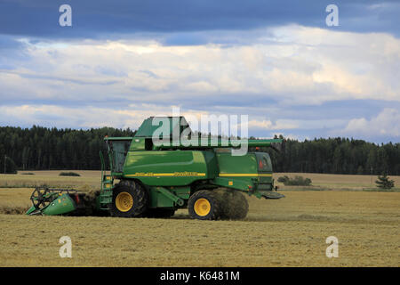 Salo, Finlande - le 25 août 2017 : moisson avec moissonneuse-batteuse John Deere 9460i à dusktime sur soirée d'automne en milieu rural au sud de la Finlande. Banque D'Images