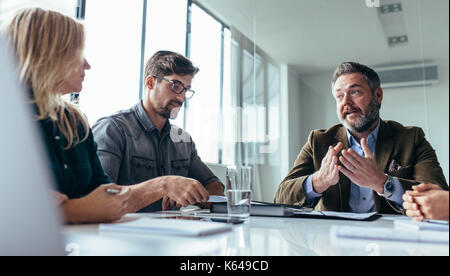 Équipe de professionnels ayant une réunion dans la salle de conférence. Businessman explaining projet à ses collègues. Banque D'Images