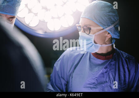 Chirurgien concentré toute intervention chirurgicale avec son équipe en salle d'opération de l'hôpital. Les médecins au cours de l'intervention en salle d'opération. Banque D'Images