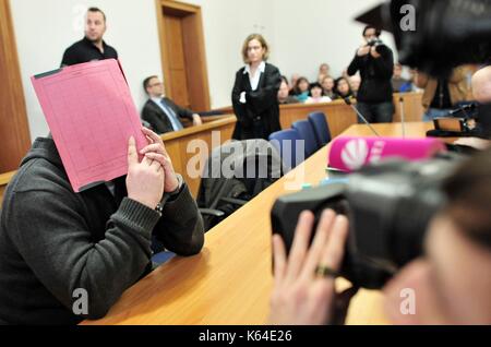 L'ancien infirmier niels h., accusé de plusieurs meurtres et attmepted meurtre de patients, dans la salle d'audience wearing handcuffs et couvrant le visage avec un dossier à la cour de district à Oldenburg (Allemagne), 19 février 2015. Dans le monde d'utilisation | Banque D'Images