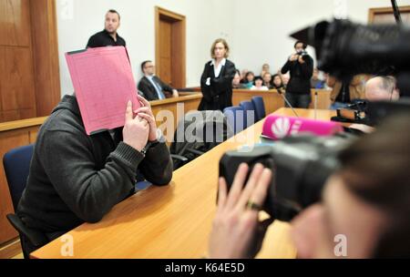 L'ancien infirmier niels h., accusé de plusieurs meurtres et attmepted meurtre de patients, dans la salle d'audience wearing handcuffs et couvrant le visage avec un dossier à la cour de district à Oldenburg (Allemagne), 19 février 2015. Dans le monde d'utilisation | Banque D'Images