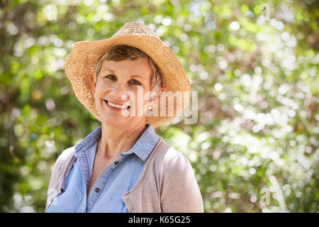 Outdoor Portrait Of Mature Woman Wearing Straw Hat Banque D'Images