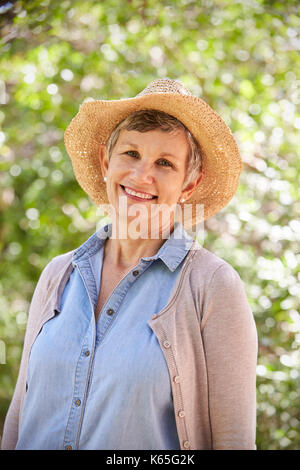 Outdoor Portrait Of Mature Woman Wearing Straw Hat Banque D'Images