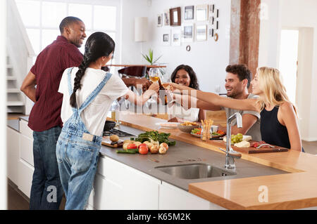 Les amis de préparer et servir de la nourriture pour le dîner de travail à la maison ensemble, Banque D'Images