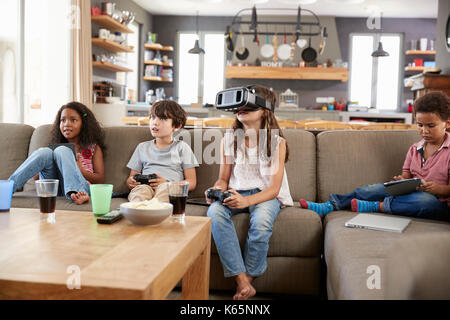 Les enfants jouent le jeu de l'ordinateur à l'aide de casque de réalité virtuelle Banque D'Images