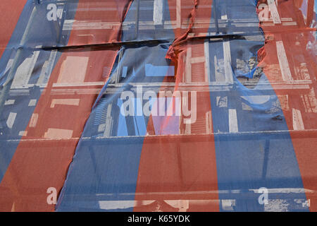 Bâtiment abandonné prêt à tomber vers le bas avec l'appui d'échafaudage et couvert par les débris colorés transparents la compensation. Banque D'Images