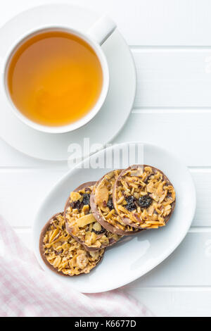 Cookies aux pépites de chocolat aux noix et raisins secs. Les cookies avec une tasse de thé. Banque D'Images