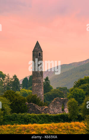 La tour ronde à Glendalough, dans le comté de Wicklow, Irlande, réputé pour l'un des premiers établissement monastique médiévale fondée au Vie siècle par saint kevin. Banque D'Images