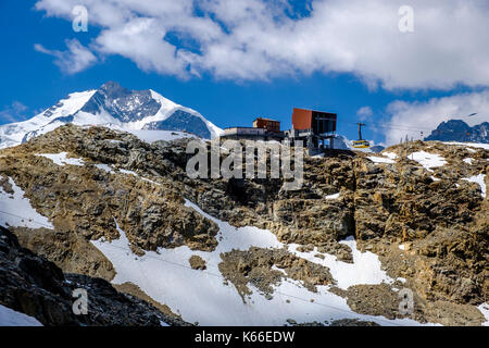 La station de téléphérique Diavolezza est située sur une crête de montagne, le sommet enneigé de la montagne Piz Bernina au loin Banque D'Images