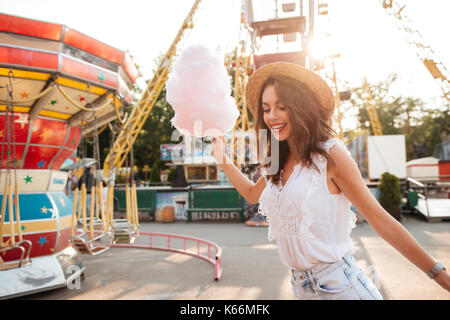 Happy smiling girl with Cotton Candy s'amuser au parc d'attractions Banque D'Images