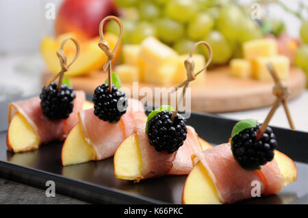 Canape de peach avec jambon séché et les mûres Banque D'Images