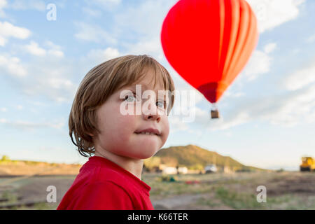 Young boy sous ballon à air chaud à distance Banque D'Images