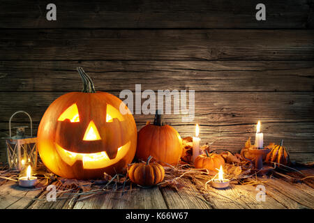 Citrouilles d'halloween et les bougies sur sol en bois Banque D'Images