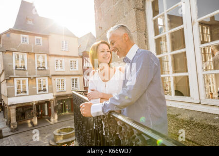 Caucasian couple smiling sur balcon en ville Banque D'Images
