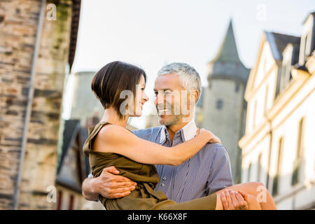 Caucasian man carrying a woman in city Banque D'Images