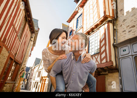 Caucasian man caring woman piggyback en ville Banque D'Images