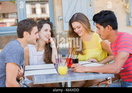 Lecture des menus d'amis au restaurant Banque D'Images