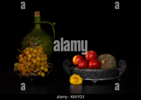 La vie encore d'automne aux pommes, raisin et de citrouille sur fond noir. Banque D'Images