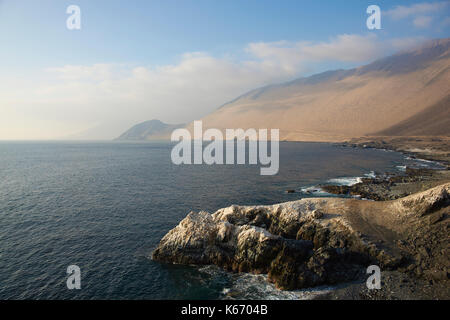 Falaises couvertes de guano blanc le long de la côte pacifique du nord du Chili. Banque D'Images