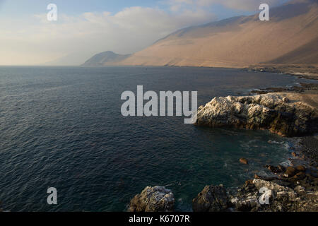 Falaises couvertes de guano blanc le long de la côte pacifique du nord du Chili. Banque D'Images