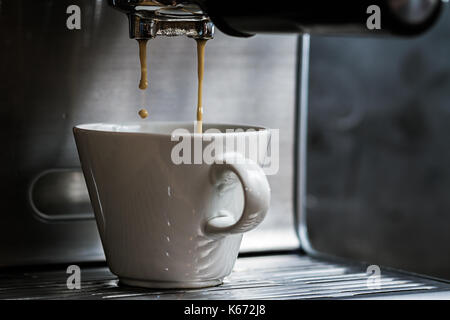 Close up shot hivernal de l'espresso des gouttes en coupe blanc Banque D'Images