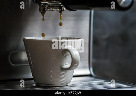 Close up shot hivernal de l'espresso des gouttes en coupe blanc Banque D'Images