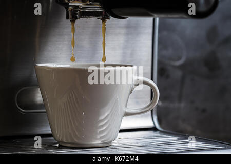 Close up shot hivernal de l'espresso des gouttes en coupe blanc Banque D'Images