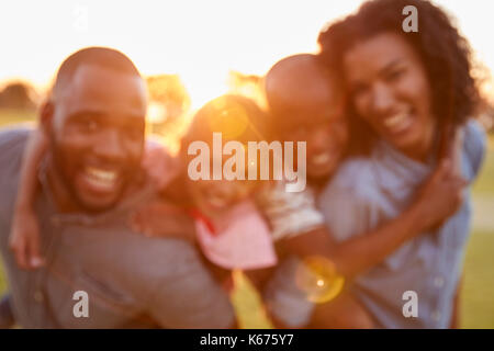 Portrait of young black couple avec enfants sur piggyback Banque D'Images