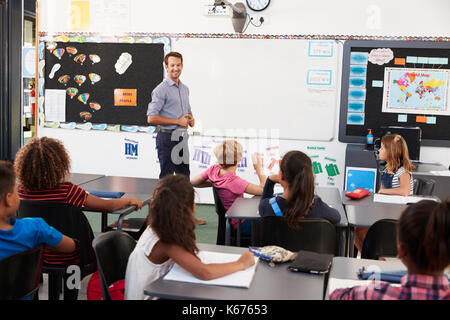 Enseignant à l'avant de la classe dans une école élémentaire leçon Banque D'Images