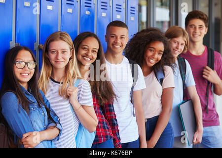 Teenage school kids smiling to camera dans couloir d'école Banque D'Images