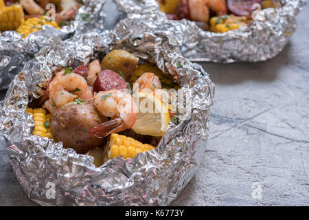 Faire bouillir les crevettes Cajun maison traditionnelle avec des pommes de terre et le maïs saucisse pack aluminium Banque D'Images