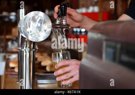 Man pulling a pint of beer in a bar Banque D'Images