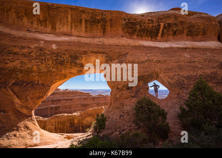 Homme debout à partition Arch, Parc national d'Arches, Utah, États-Unis Banque D'Images