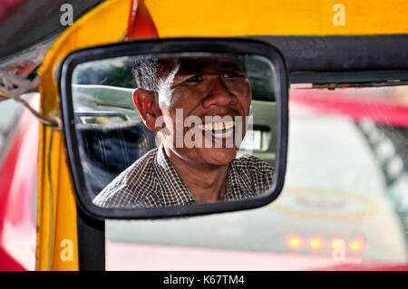 Smiling tuk-tuk driver en miroir, Samphanthawong District, Bangkok, Thaïlande Banque D'Images