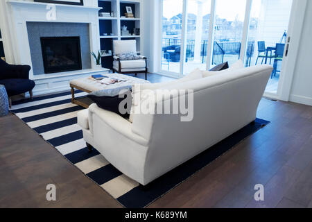 Un canapé blanc dans un salon donnant sur un patio extérieur. Banque D'Images