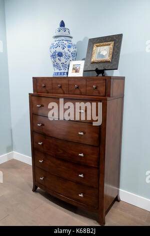 Un érable commode avec un pot et des photos de famille dans une chambre à coucher principale. Banque D'Images