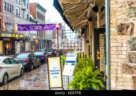 La ville de Québec, Canada - 31 mai 2017 : rue de la vieille ville rue Saint-Jean lors d'une forte averse de pluie avec des gouttes et éclaboussures, route mouillée par des restaurants, boutiques Banque D'Images