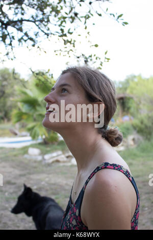 Teenage girl avec cheveux tirés en arrière en un chignon à l'extérieur en été. Vu de côté. Banque D'Images