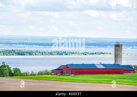 Vue aérienne du paysage urbain des terres agricoles de l'île d'Orléans, Québec, Canada, champ labouré, sillons, et silo de stockage du grain de la ferme grange, hangar ou par sain Banque D'Images