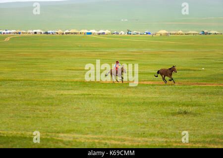 Oulan-bator, Mongolie - 12 juin 2007 : jeune garçon à cheval dans le peloton à la compétition de course de chevaux de l'événement festival naadam Banque D'Images