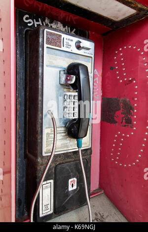 Téléphone public à pièces abandonnées avec coin presse logement. Banque D'Images