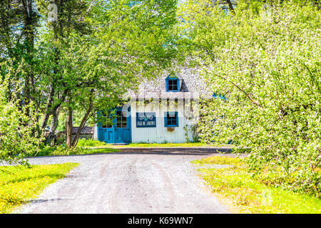 L'ÎLE D'Orléans, Canada - 1 juin 2017 : Blue house avec roadin paysage d'été campagne française avec Vignoble vineyard winery ou signer et chemin de terre Banque D'Images