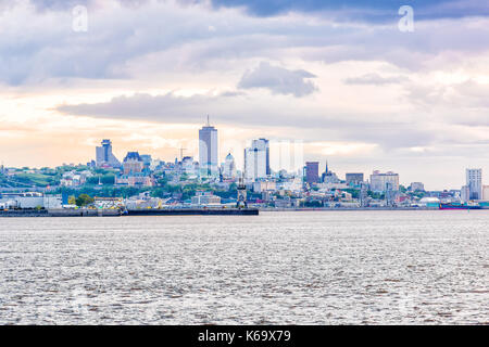Cityscape skyline of Quebec City, Canada during sunset with port or pier in Levis with dramatic cloudy cloud sky, sun reflection Banque D'Images